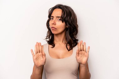 Beyaz arka planda izole edilmiş genç İspanyol kadın elini uzatmış, dur işareti göstererek seni engelliyor..