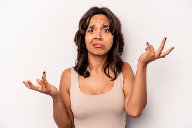 Beyaz arka planda izole edilmiş genç bir İspanyol kadın şüpheli bir tavırla omuz silkiyor..
