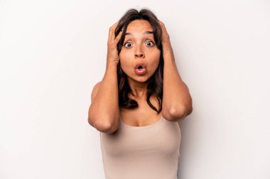 Beyaz arka planda izole edilmiş genç İspanyol kadın şaşırmış ve şok olmuş..