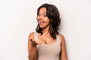 Beyaz arka planda izole edilmiş genç İspanyol kadın selamlama jesti olarak kameraya elini uzatıyor..