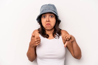 Latin kökenli genç bir kadın beyaz arka planda izole edilmiş, baş parmağını kaldırıyor, zor seçim konsepti.