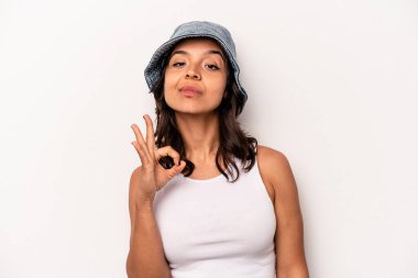 Beyaz arka planda izole edilmiş genç bir İspanyol kadın bir göz kırptı ve elleriyle iyi bir jest yaptı..