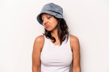 Beyaz arka planda izole edilmiş genç İspanyol kadın omuz silkiyor ve gözleri açık..