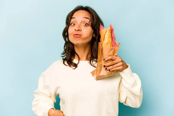 Young Hispanic Woman Eating Sandwich Isolates Blue Background — Stockfoto