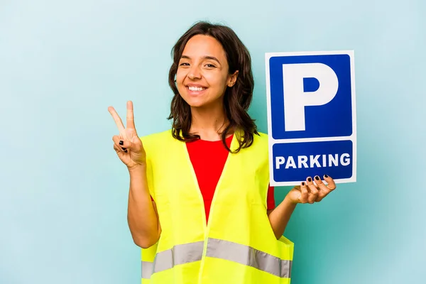 年轻的惊慌失措的女人拿着蓝色背景的停车标牌 — 图库照片