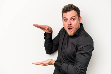 Beyaz arka planda izole edilmiş genç beyaz adam elleri arasında bir kopya alanı tutarken şok ve hayrete düştü..