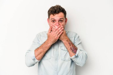 Beyaz arka planda izole edilmiş genç beyaz bir adam ağzı kapalı ve elleri endişeli görünüyor..