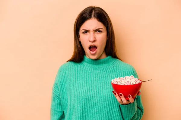 Giovane Donna Ispanica Mangiare Cereali Isolati Sfondo Beige Urlando Molto — Foto Stock