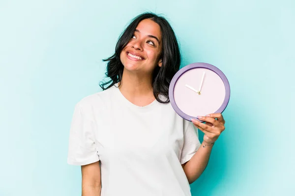 Young Hispanic Woman Holding Clock Isolated Blue Background Dreaming Achieving — Fotografia de Stock