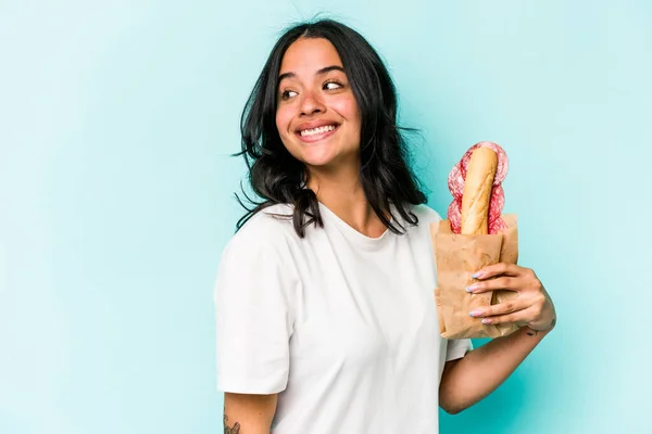 Ung Latinamerikansk Kvinna Äter Smörgås Isolerad Blå Bakgrund Ser Sidan — Stockfoto