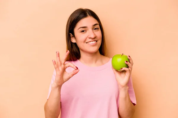 Young Hispanic Woman Holding Apple Isolated Beige Background Cheerful Confident — Stock Photo, Image