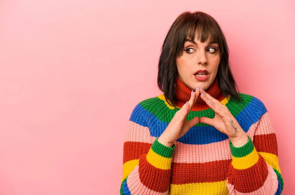 Kafkasyalı genç bir kadın pembe arka planda izole edilmiş bir plan yapıyor, bir fikir kuruyor..