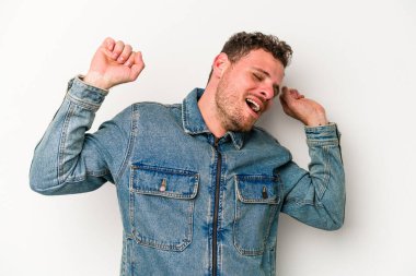 Beyaz arka planda izole edilmiş genç beyaz adam kollarını uzatıyor, rahat bir konumda..