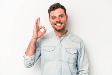 Beyaz arka planda izole edilmiş genç beyaz bir adam neşeli ve kendinden emin..