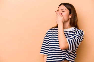 Genç İspanyol kadın bej arka planda izole edilmiş gülerek, kaygısızca, doğal duygularla gülüyor..