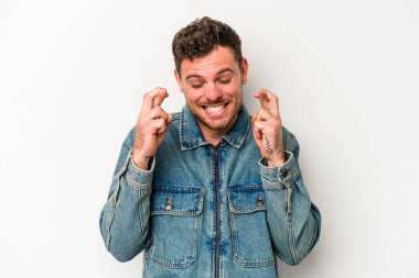 Beyaz arka planda izole genç beyaz adam şans dilemek için şans diliyor.