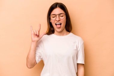 Bej arka planda izole edilmiş genç İspanyol kadın parmaklarıyla taş hareketi gösteriyor.