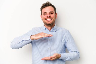 Beyaz arka planda izole edilmiş beyaz bir adam iki eliyle bir şey tutuyor..