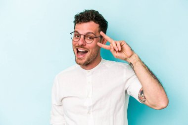 Genç beyaz adam mavi arka planda izole edilmiş dans ediyor ve eğleniyor..