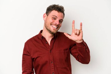 Beyaz arka planda izole edilmiş genç beyaz bir adam boynuzlarını devrim konsepti olarak gösteriyor..