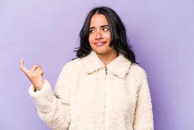 Mor arka planda izole edilmiş genç İspanyol kadın sanki seni davet ediyormuş gibi seni işaret ediyor..