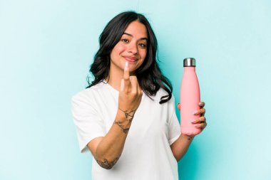 Mavi arka planda termosu olan genç İspanyol kadın seni işaret ediyor. Sanki seni davet ediyormuş gibi..