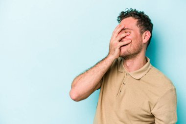 Kafkasyalı genç adam mavi arka planda yalnızdı gülerek, kaygısızca, doğal duygularla.