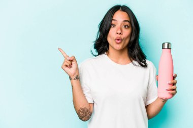 Mavi arka planda termometreyi tutan genç İspanyol kadın...