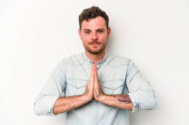 Beyaz arka planda izole edilmiş genç beyaz adam dua ediyor, bağlılık gösteriyor, dindar biri ilahi ilham arıyor..