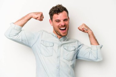 Beyaz arka planda izole edilmiş genç beyaz bir adam güçlü bir hareket gösteriyor, kollarıyla, kadınsı gücün sembolü.