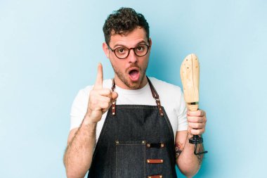 Kafkasyalı genç kunduracı, mavi arka planda izole edilmiş. Bir fikri var, ilham verici bir kavram..