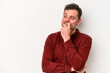 Beyaz arka planda izole edilmiş genç beyaz bir adam rahatlamış bir şeyin fotokopi odasına baktığını düşünüyor..