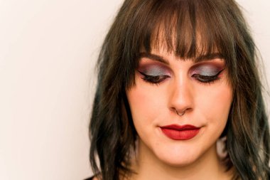 Beyaz arka planda izole edilmiş beyaz makyajlı genç bir kadın.