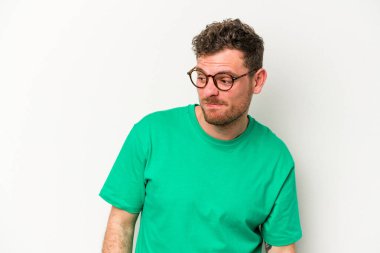 Beyaz arka planda izole edilmiş genç beyaz bir adam omuz silkiyor ve gözleri açık..