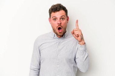 Beyaz arka planda izole edilmiş genç beyaz adam ağzı açık bir şekilde üst tarafı işaret ediyor..