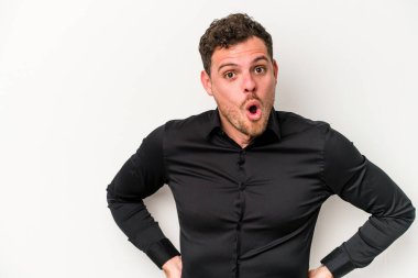 Beyaz arka planda izole edilmiş genç beyaz adam gördüğü bir şey yüzünden şoka uğruyor..