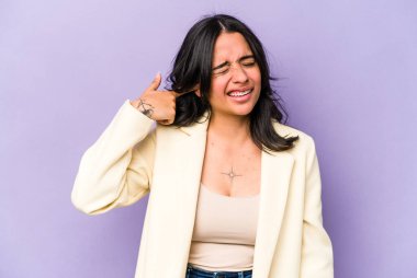 Mor arka planda izole edilmiş genç İspanyol kadın kulaklarını elleriyle kapatıyor..