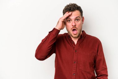 Beyaz arka planda izole genç beyaz adam yüksek sesle bağırıyor, gözleri açık ve elleri gergin tutuyor..