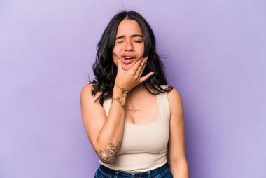 Mor arka planda izole edilmiş genç İspanyol kadın güçlü bir diş ağrısı, azı dişi ağrısı var..