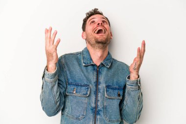 Beyaz arka planda izole edilmiş genç beyaz adam gökyüzüne haykırıyor, yukarı bakıyor, hayal kırıklığına uğramış..