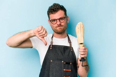 Kafkasyalı genç kunduracı, mavi arka planda izole edilmiş, hoşlanmadığı bir hareket sergiliyor. Anlaşmazlık konsepti.