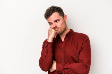 Beyaz arka planda izole edilmiş, üzgün ve dalgın hisseden genç beyaz bir adam fotokopi alanına bakıyor..