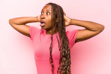 Genç Afrikalı Amerikalı kadın pembe arka planda izole edilmiş bağırıyor, çok heyecanlı, tutkulu, bir şeyden memnun..