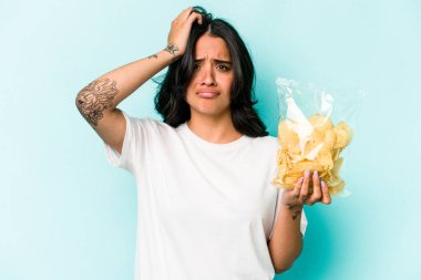 Mavi arka planda izole edilmiş bir paket cipsi tutan genç İspanyol kadın şok geçiriyordu. Önemli bir toplantıyı hatırladı..