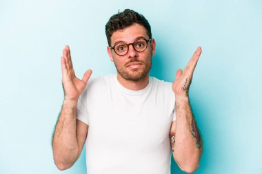 Kafkasyalı genç bir adam mavi arka planda izole edilmiş. Bir fikri, ilham verici bir fikri var..