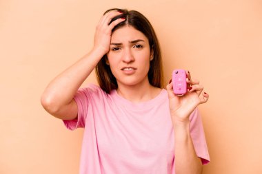 Latin kökenli genç bir kadın bej arka planda izole edilmiş bir araba tutuyordu. Şok geçiriyordu. Önemli bir toplantıyı hatırladı..