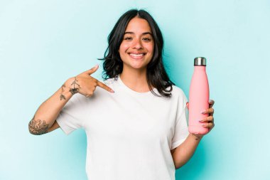 Mavi arka planda termometreyi tutan genç İspanyol kadın gömlek fotokopisini elle gösteriyor, gururlu ve kendinden emin