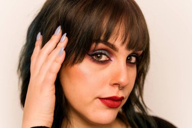 Beyaz arka planda izole edilmiş beyaz makyajlı genç bir kadın.