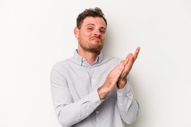 Beyaz arka planda izole olmuş genç beyaz bir adam enerjik ve rahat hissediyor, ellerini ovuşturuyor..