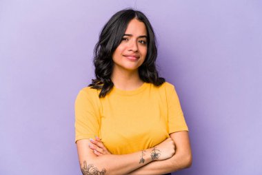 Mor arka planda izole edilmiş genç İspanyol kadın şüpheli, belirsiz, seni muayene ediyor..